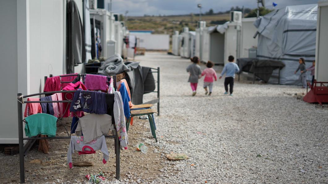 Kinderen lopen langs wasrekken in een vluchtelingenkamp in Griekenland